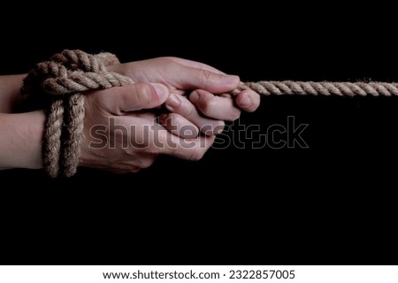 Tied hands with a rope on a black background