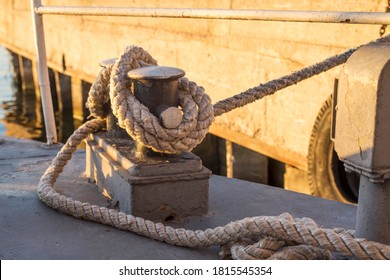 Tied Rope Knot On Metallic Bollard , Seafaring Port. Nautical Ship Moored In Dock. Anchor Rope In The Port, Ship Mooring Tool.