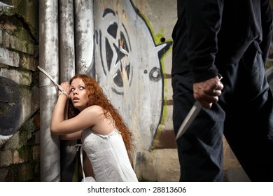 Tied Woman Is Looking At A Man With A Knife