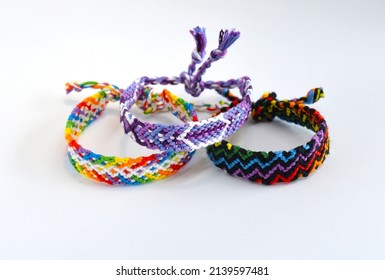 Tied woven friendship bracelet with bright colorful pattern handmade of thread isolated on white background - Shutterstock ID 2139597481