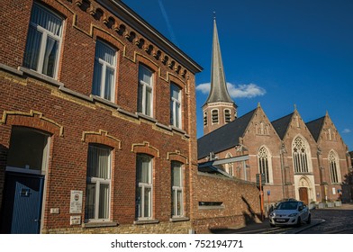 Tielt, Belgium - July 02, 2017. Church and belfry with brick building at sunset in Tielt. Charming village in the countryside, near Ghent and surrounded by agricultural fields. Western Belgium.