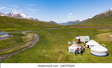 Tien Shan Mountains, Kyrgyzstan - June 25th 2019: Aerial Shot Of The Expedition Team Setting Up Base Camp In A Remote Valley