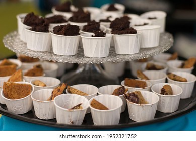 A Tiered Display Of Cookie And Brownie Samples In Miniature Paper Cups