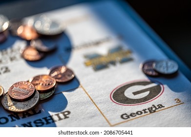 Tiffin, Iowa, USA - 12.2022 - Selective Focus On 2021-2022 College Football Playoff Bracket With Scattered Coins.