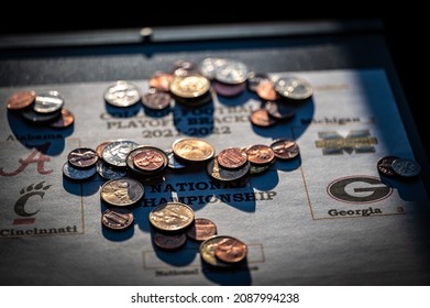 Tiffin, Iowa, USA - 12.2022 - Selective Focus On 2021-2022 College Football Playoff Bracket With Scattered Coins.