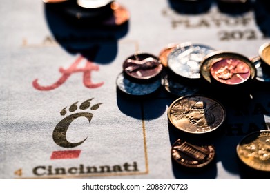 Tiffin, Iowa, USA - 12.2022 - Selective Focus On 2021-2022 College Football Playoff Bracket With Scattered Coins.