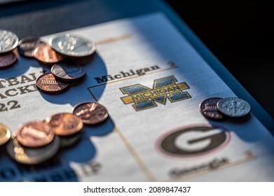 Tiffin, Iowa, USA - 12.2022 - Selective Focus On 2021-2022 College Football Playoff Bracket With Scattered Coins.