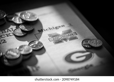 Tiffin, Iowa, USA - 12.2022 - Selective Focus On 2021-2022 College Football Playoff Bracket With Scattered Coins.