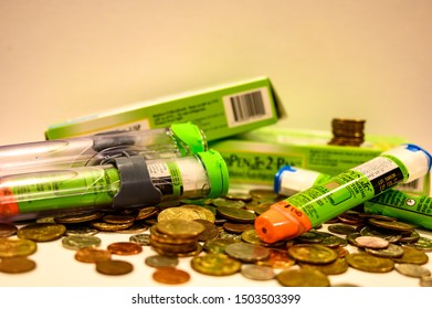 Tiffin, Iowa, USA - 8/2019:   EpiPen (an Epinephrine Injector) On Top Of A Pile Of Coins