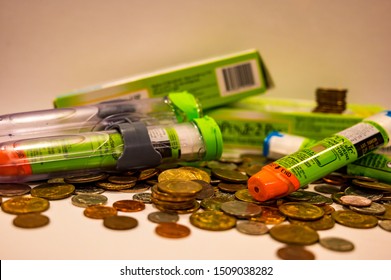 Tiffin, Iowa, USA - 8/2019:   EpiPen (an Epinephrine Injector) On Top Of A Pile Of Coins