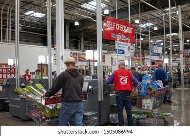 Tigard, OR, USA - Sep 12, 2019: Self checkout lanes in a Costco Wholesale store in Tigard, a southwestern suburb within the Portland metro area. Staff uniform is seen advertising Costco App.