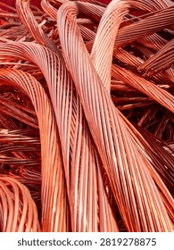 Tight closeup of thick stranded copper wires twisted and coiled into flowing loops, showing metallic sheen, warm orange brown colour, fine strand detail, and reflective highlights, composition fills
