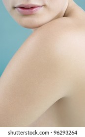 Tight crop of a woman's bare shoulders and lips.