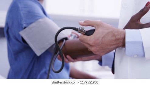 Tight shot of young MD checking senior womans blood pressure with stethoscope