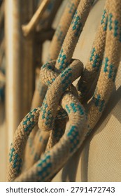 Tight vertical composition of braided lines and knots on sailboat rigging.