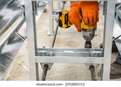 Tightening of bolts nuts screw washer in concrete surface. Cable tensioning. Installation of support in crash barriers on highway. Bridge construction. Metal road fencing on freeway. Road guard rails.