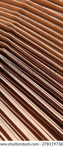Tightly folded stack of kraft Brown paper. Abstract diagonal Linear Texture and Geometric Pattern Background. Close up.
