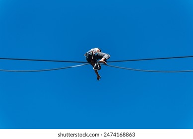 a tightrope walker in nature. Natural outdoor tightrope walker. Acrobat on a high wire. Tightrope walker on a tight rope. Tightrope walker outside. Balance - Powered by Shutterstock