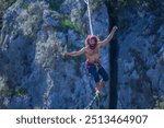 A tightrope walker walks along a cable stretched over a canyon.