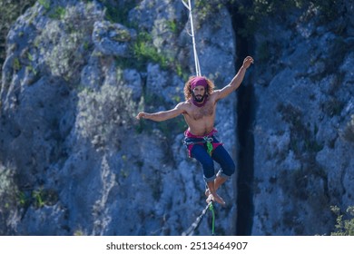 A tightrope walker walks along a cable stretched over a canyon. - Powered by Shutterstock