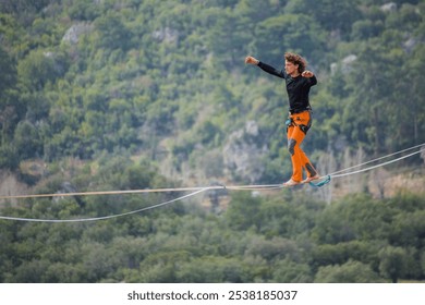 A tightrope walker walks along a cable stretched over a canyon. - Powered by Shutterstock