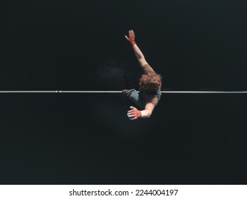 A tightrope walker walks along a line above the water. extreme sports