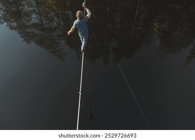 The tightrope walker walks over the water. Aerial view. Themes of slackline, highline and waterline. Extreme activity.