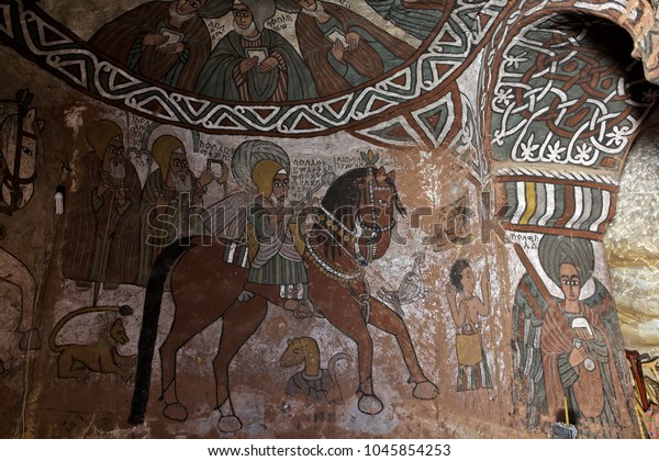 TIGRAY REGION, ETHIOPIA – February 10, 2018: wall murals of saints and iconographic scenes, painted in naive african christian style, on wall of Abuna Yemata Guh church