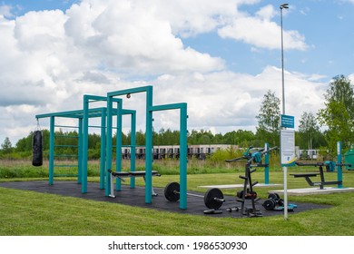 Tila, Estonia - May 28, 2021: Empty Outdoor Gym. Outdoor Gym Equipment Near The Gas Station. Apartment Buildings In The Background. Selective Focus.
