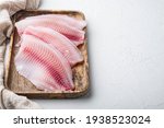 Tilapia fish, skinless meat, on white background with copy space for text