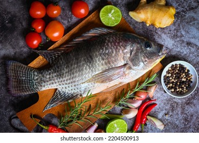 Tilapia with spice rosemary tomato
lemon lime ginger garlic pepper chili on dark background, Fresh raw tilapia fish from the tilapia farm - top view - Powered by Shutterstock