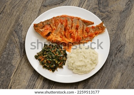Tilapia stew, ugali(white maize flour mash) and Sukuma Wiki(kale stew), Kenyan food
