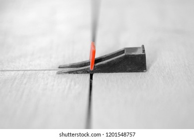 Tile alignment system. Black and orange color. Close up