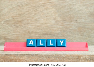 Tile alphabet letter with word ally in red color rack on wood background - Shutterstock ID 1976653703