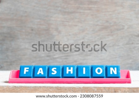 Tile alphabet letter with word fashion in red color rack on wood background