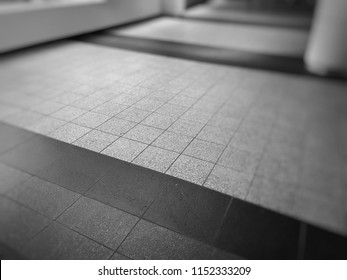 A tile floor pattern in the lobby of a parking garage.