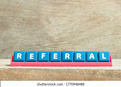 Tile Letter On Red Rack In Word Referral On Wood Background