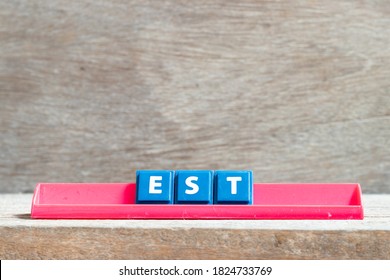 Tile Letter On Red Rack In Word Est (abbreviation Of Established, Estimated, Eastern Time Zone, Expressed Sequence Tag) On Wood Background