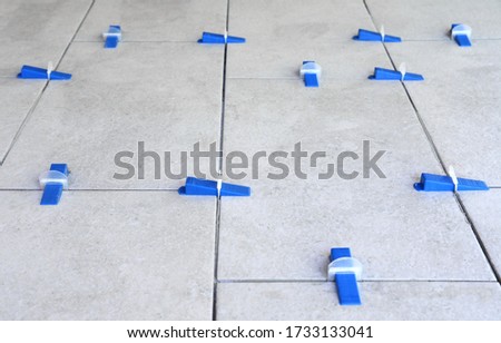 Tile leveling system with plastic clips and wedges, shot while the tile mortar sets