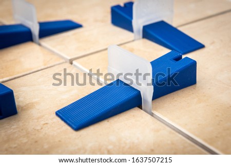 Tile levelling system with plastic clips and wedges.