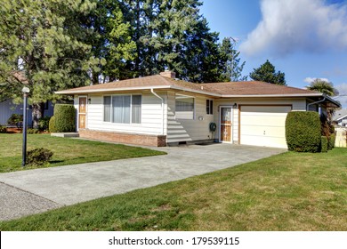 Tile Roof Siding House With A Garage And Concrete Drive Way