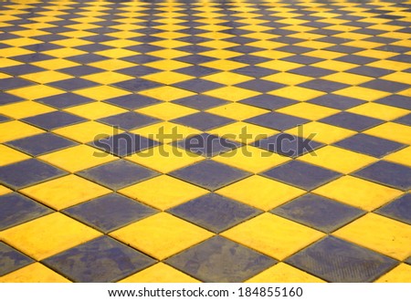 Tile walkway with yellow and black stripes.
