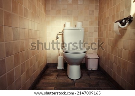 Tiled brown water closet toilet room.