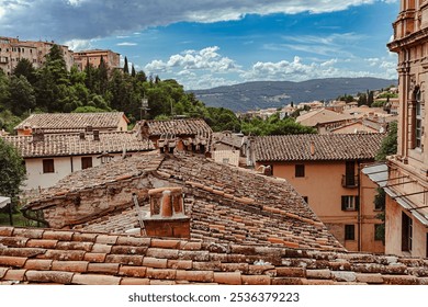 Tiled roofs of medieval Perugia, showcasing the historic architecture of Umbria amid scenic hills and distant mountains - Powered by Shutterstock