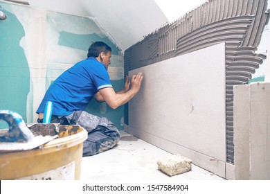 Tiler installing large format tile on wall. home indoors renovation
