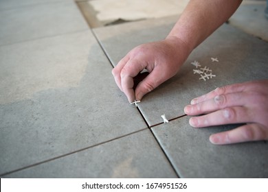 Tiler laying the ceramic tile on the floor. Professional worker makes renovation. Construction. Hands of the tiler. Home renovation and building new house