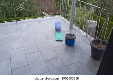 Tiler Laying  Tiles On The Floor Of A Balcony And Grouted.