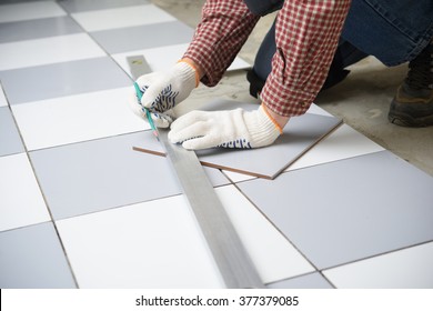 Tiler Marks The Tile During The Floor Installation