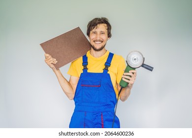 A tiler, a tiling specialist, holds a tile cutter in his hands
