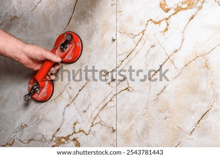 Tilers installing large format tiles on wall. 